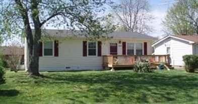 back of house with a wooden deck and a lawn