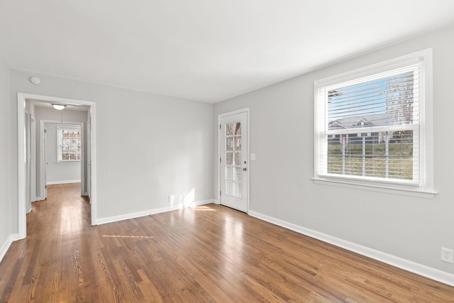 spare room featuring hardwood / wood-style flooring and a healthy amount of sunlight