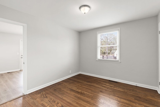 spare room featuring dark hardwood / wood-style flooring