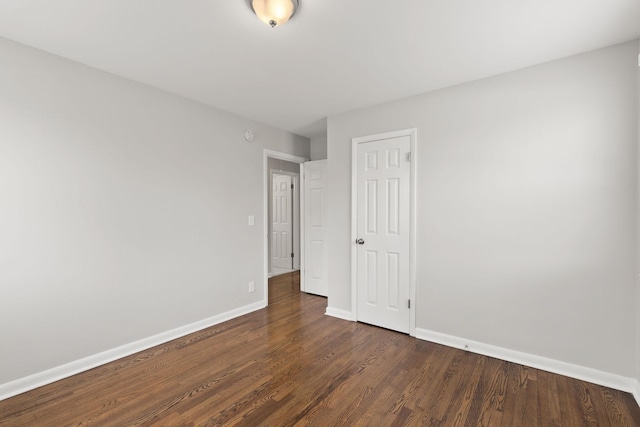 empty room with dark hardwood / wood-style flooring