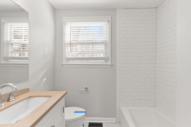 bathroom featuring vanity, toilet, and a wealth of natural light