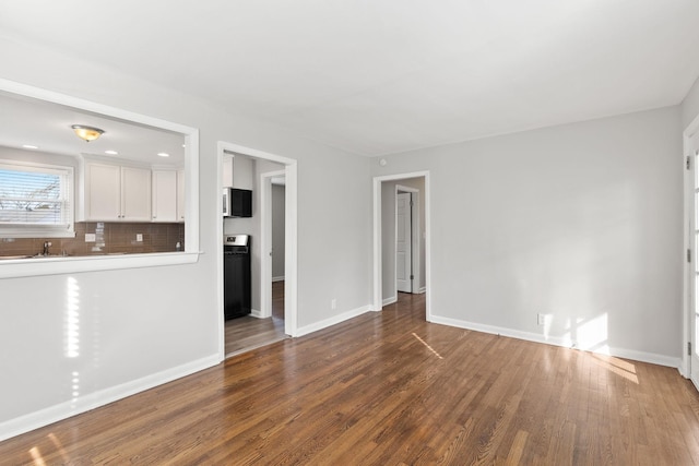 unfurnished living room with sink and wood-type flooring