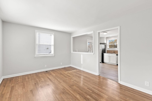 unfurnished room featuring sink and hardwood / wood-style floors