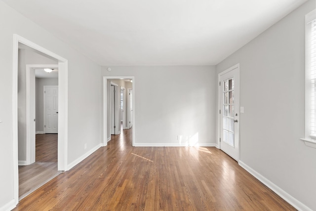 spare room featuring a wealth of natural light and dark hardwood / wood-style flooring