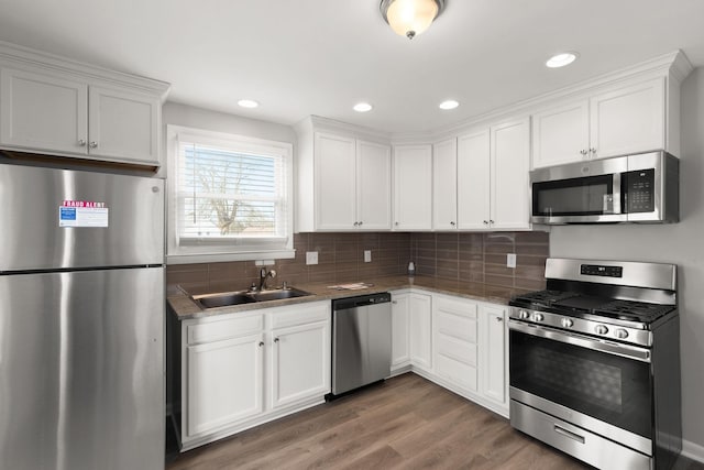 kitchen with appliances with stainless steel finishes, sink, and white cabinets