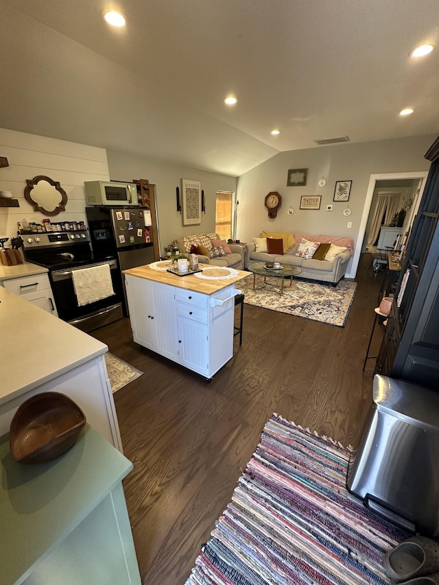 kitchen featuring butcher block countertops, dark wood-type flooring, white cabinetry, stainless steel range with electric stovetop, and a kitchen island