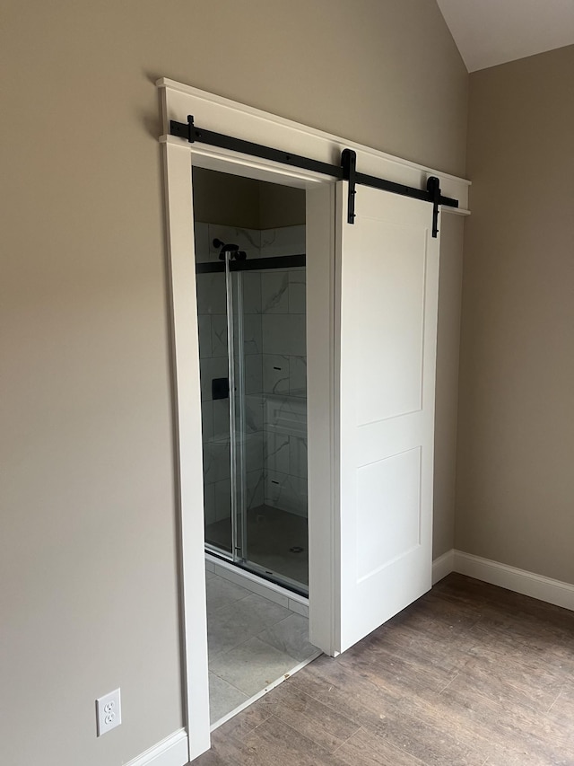 bathroom with hardwood / wood-style flooring and an enclosed shower