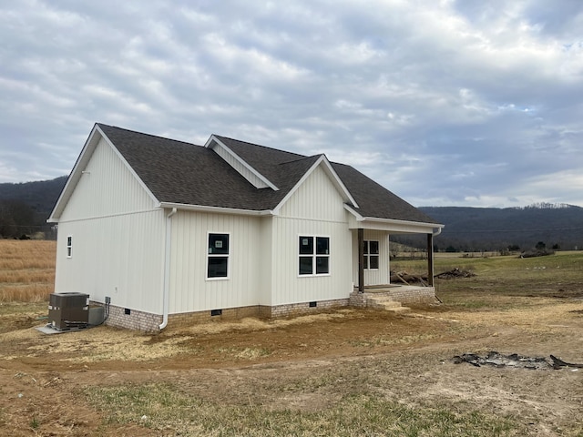 exterior space with cooling unit, a porch, and a mountain view