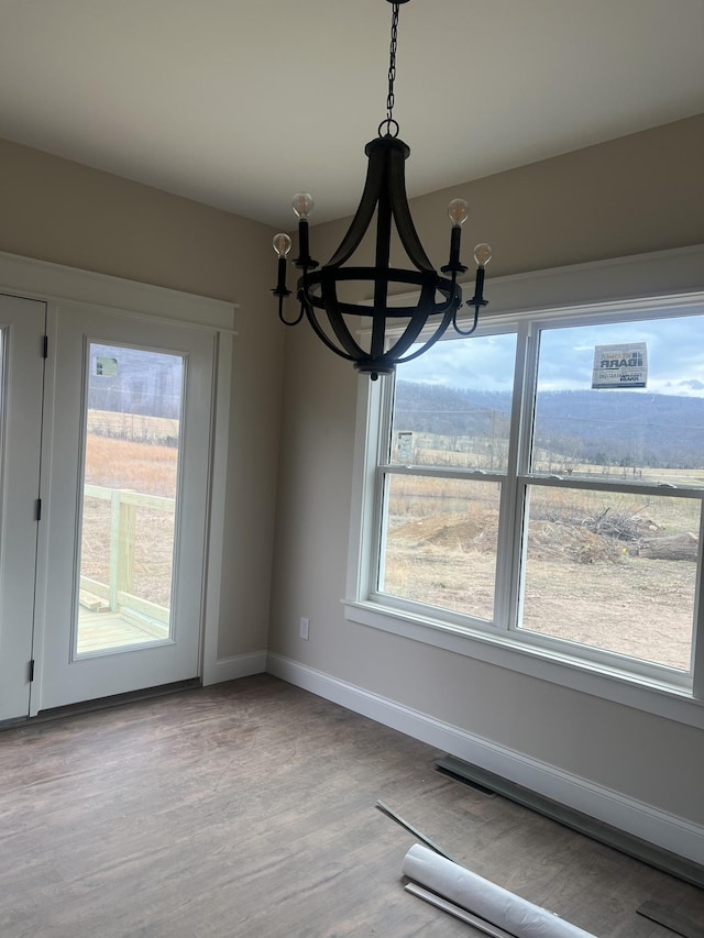 unfurnished dining area with hardwood / wood-style flooring and a notable chandelier