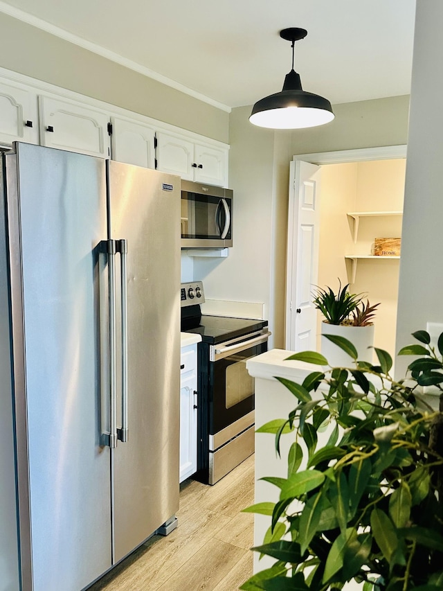 kitchen featuring white cabinetry, appliances with stainless steel finishes, pendant lighting, and light hardwood / wood-style floors