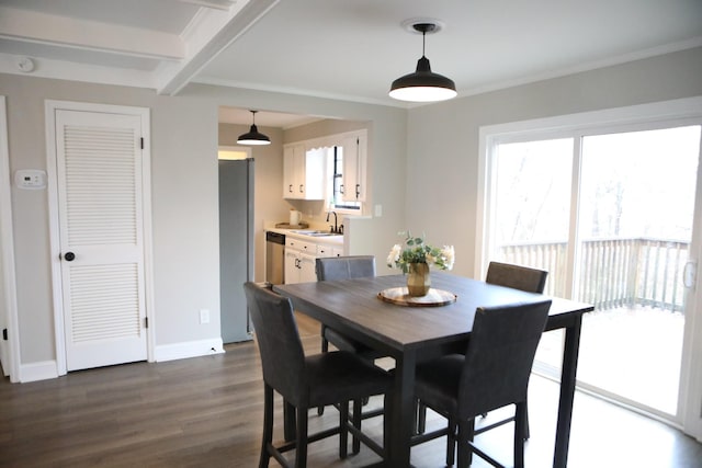 dining space with beamed ceiling, a healthy amount of sunlight, dark hardwood / wood-style floors, and sink