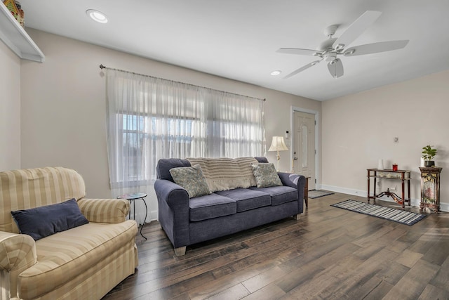 living room with dark wood-type flooring and ceiling fan