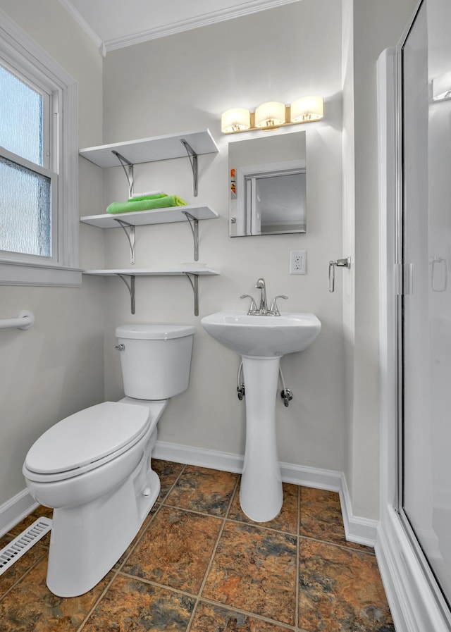 bathroom featuring crown molding and toilet