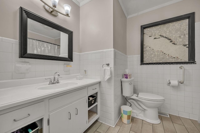 bathroom featuring vanity, ornamental molding, tile walls, and toilet