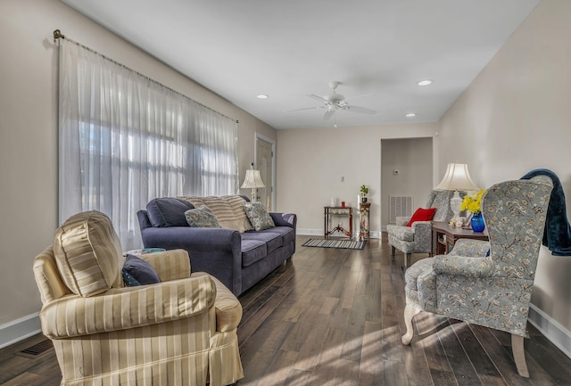 living room featuring dark wood-type flooring and ceiling fan