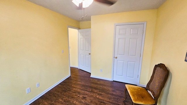 unfurnished room with a ceiling fan, baseboards, and dark wood-type flooring