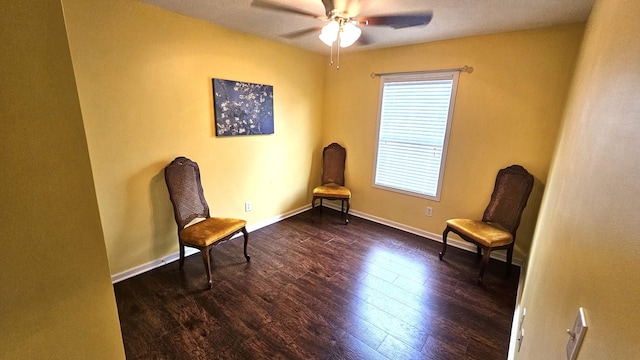 living area with dark wood-style flooring, a ceiling fan, and baseboards