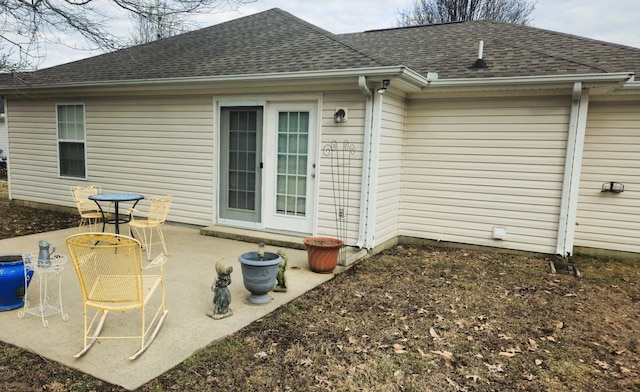 back of property featuring a patio area and roof with shingles