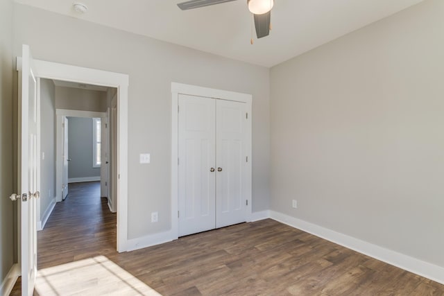 unfurnished bedroom featuring dark hardwood / wood-style floors, ceiling fan, and a closet