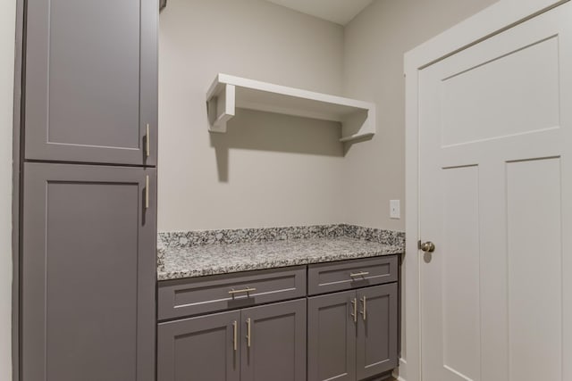 kitchen with light stone counters and gray cabinets