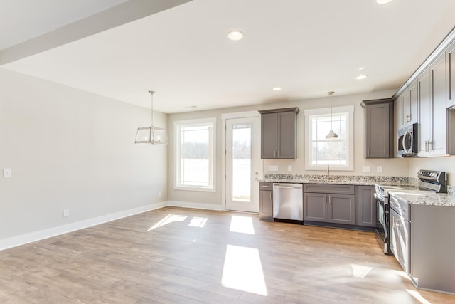 kitchen featuring pendant lighting, sink, plenty of natural light, and appliances with stainless steel finishes