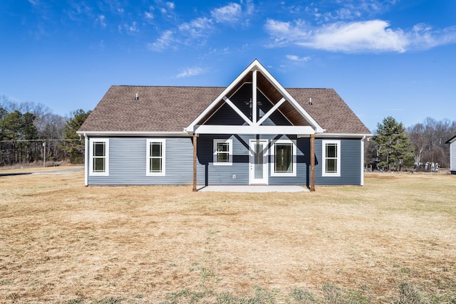 rear view of house featuring a lawn and a patio