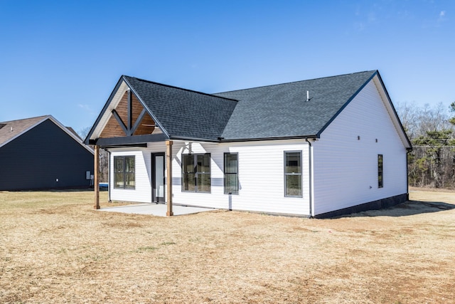 back of property with a lawn and a patio