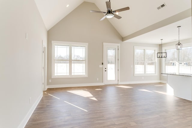 unfurnished living room featuring ceiling fan, high vaulted ceiling, and light wood-type flooring