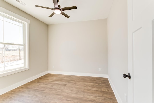 spare room featuring light hardwood / wood-style flooring, a wealth of natural light, and ceiling fan