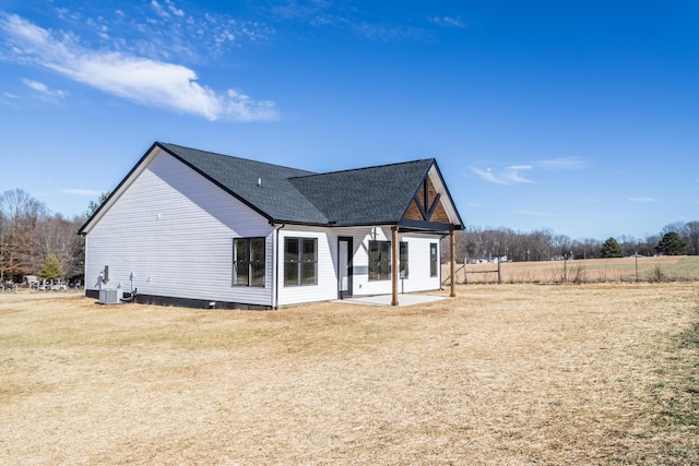 exterior space with cooling unit, a front lawn, and a patio