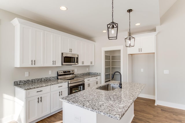 kitchen with white cabinetry, stainless steel appliances, a kitchen island with sink, and sink