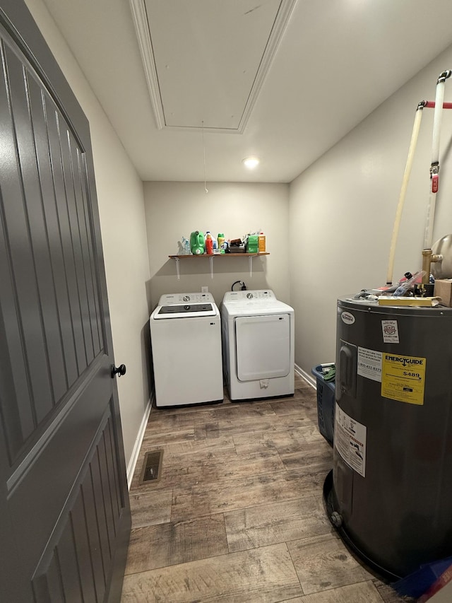 washroom featuring hardwood / wood-style floors, electric water heater, and washing machine and dryer