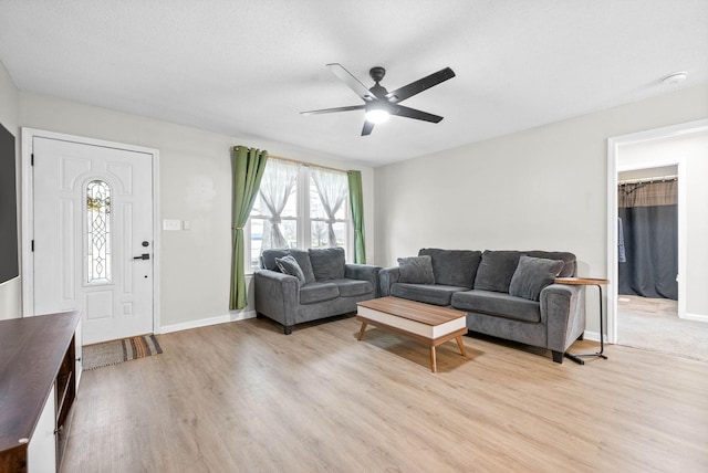 living room with light hardwood / wood-style flooring and ceiling fan