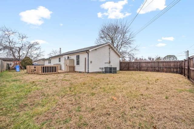 rear view of property featuring a yard, a playground, and central air condition unit