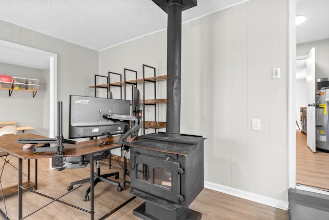 office space featuring hardwood / wood-style floors, a textured ceiling, and a wood stove