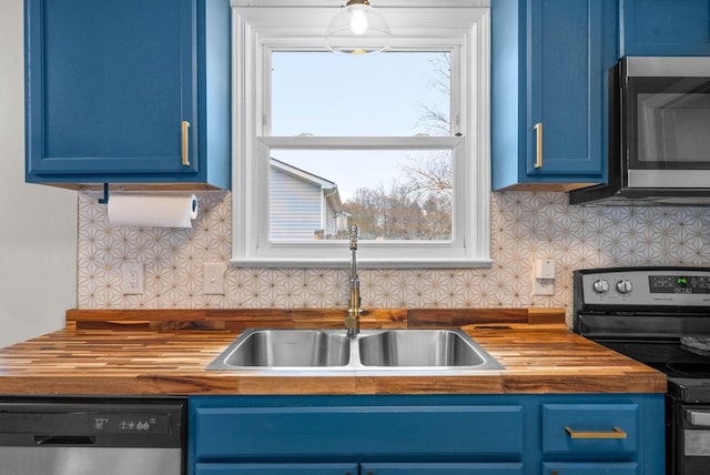 kitchen featuring blue cabinetry, stainless steel appliances, sink, and a wealth of natural light