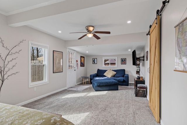 carpeted bedroom with ceiling fan and a barn door