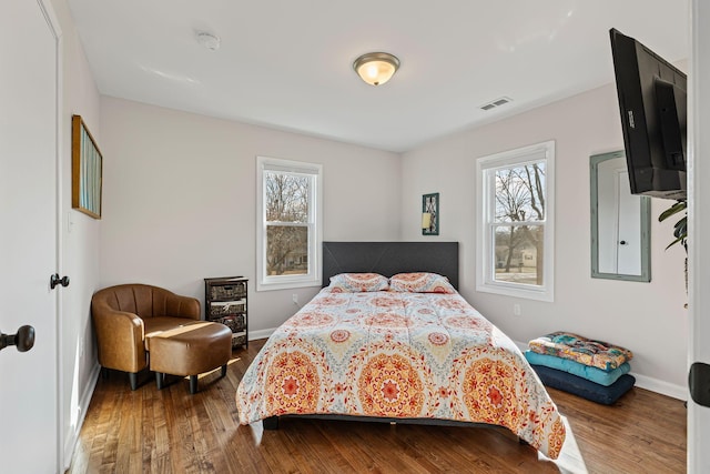 bedroom with wood-type flooring and multiple windows