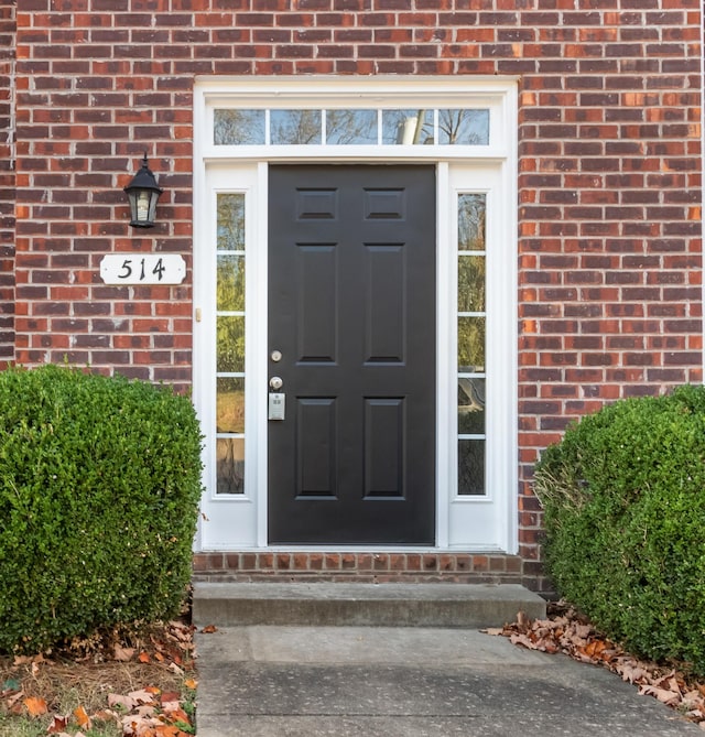 doorway to property featuring brick siding