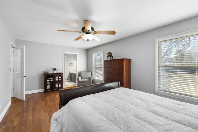 bedroom with multiple windows, wood-type flooring, ceiling fan, and ensuite bath