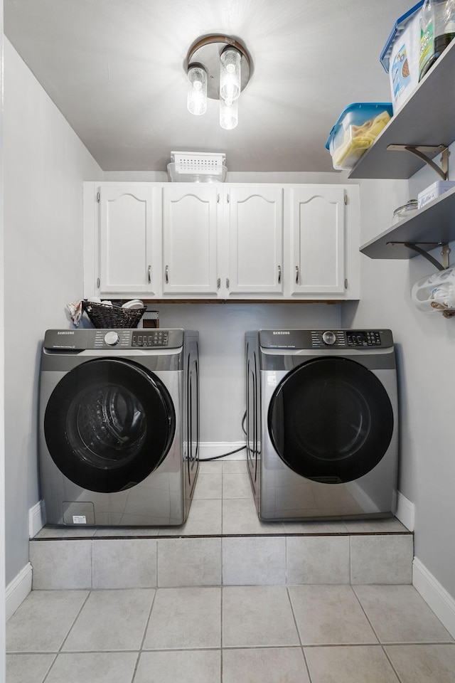 washroom featuring separate washer and dryer, cabinets, and light tile patterned flooring