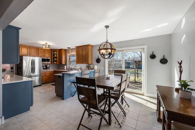 tiled dining room with sink and a notable chandelier