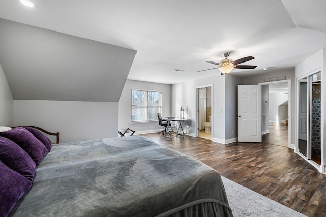 bedroom featuring dark hardwood / wood-style flooring, vaulted ceiling, ceiling fan, and ensuite bathroom