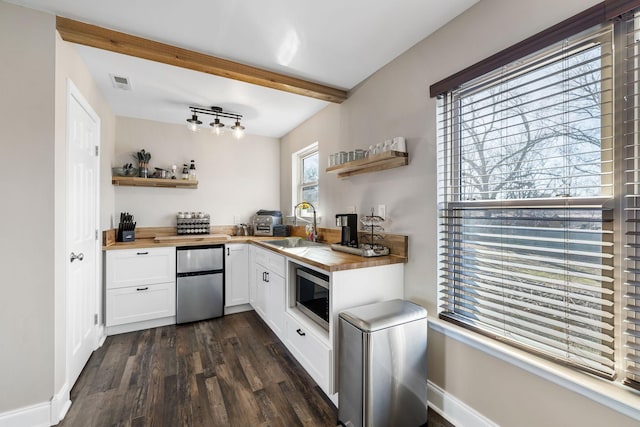 kitchen featuring dark wood-type flooring, sink, wooden counters, fridge, and white cabinets