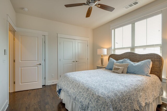 bedroom featuring dark wood-type flooring, ceiling fan, and a closet