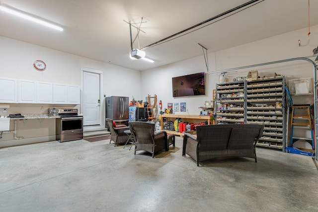 garage featuring a garage door opener, stainless steel fridge, and a workshop area