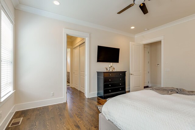 bedroom with crown molding, dark wood-type flooring, a closet, and ceiling fan