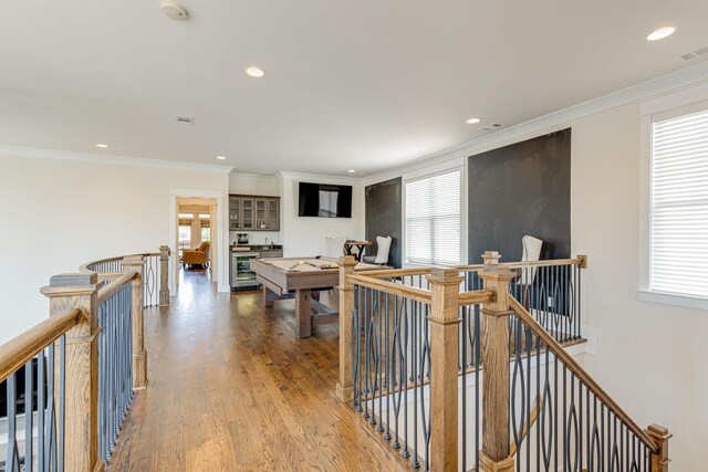 corridor featuring crown molding, beverage cooler, and hardwood / wood-style flooring