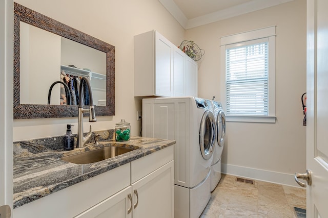 laundry area featuring sink, ornamental molding, cabinets, and independent washer and dryer