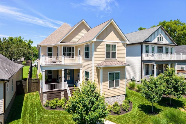 view of front facade featuring a front yard, a balcony, and covered porch